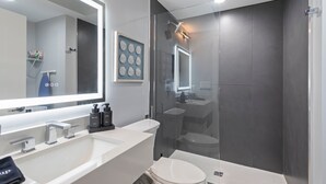 A modern bathroom with a large mirror, a shower, and a toilet. - Ammos Luxury Living- Paros Suite (Ventnor City)