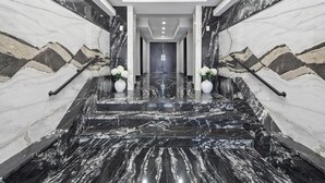 A marble staircase with a modern design, leading to a door at the end.