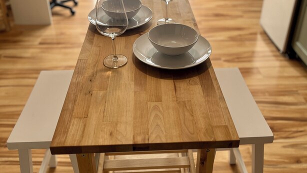 Een houten eettafel met een wit frame, gecombineerd met een witte stoel.