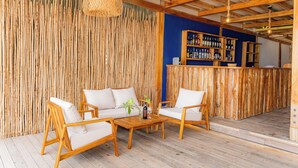 A wooden interior with a bamboo wall, a bar area, and seating with cushions. - Mar Barú Beach House (Cartagena)