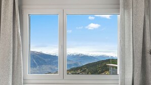 Una stanza con un'ampia finestra vista montagna.