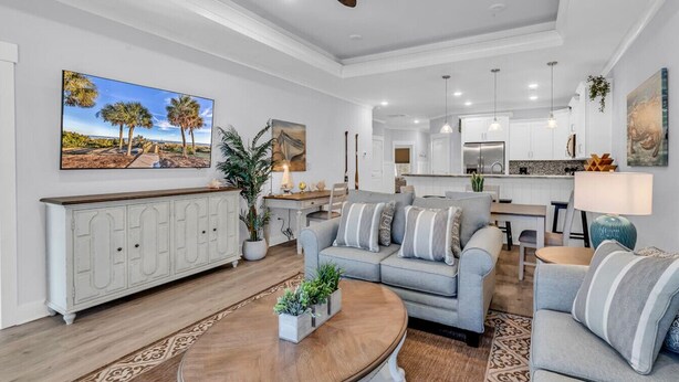 A spacious living room with a grey sofa, a coffee table, and a white cabinet. - Luxury Pondside Retreat (Murrells Inlet)