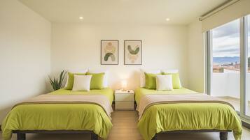 A hotel room with two beds, a nightstand, a lamp, and a large window with a city view.
