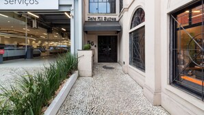 Entrada a un edificio con un letrero que dice "Jate All Suites" y el número "56" sobre la puerta.