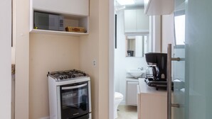 Una cocina compacta con estufa, horno y refrigerador.
