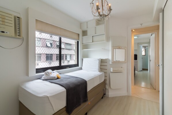 A bedroom with a bed, a window, a chandelier, and a view of buildings outside. - Near Sugarloaf Mountain Gsv302 (Rio de Janeiro)