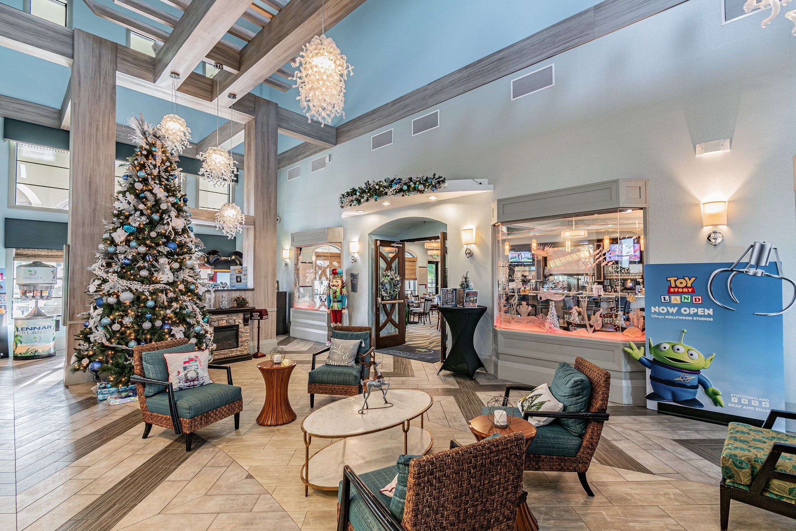 Een ruime lobby met een grote kerstboom, comfortabele zitplaatsen en een Toy Story Band winkel.