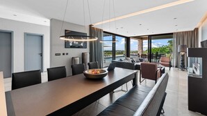 A modern hotel room with a dining area, a sofa set, and a view of the outdoors. - Villa Visignano with heated pool and welness facilities (Višnjan)
