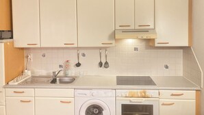 A kitchen with white cabinets, a washing machine, and an oven. - Cosy, well-connected Flat near Vienna city center and the central train station (Vienna)
