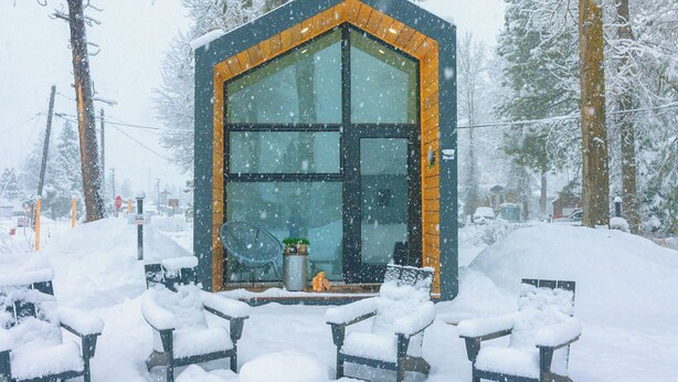 Ein modernes Gebäude mit großen Fenstern und einer schneebedeckten Fassade.