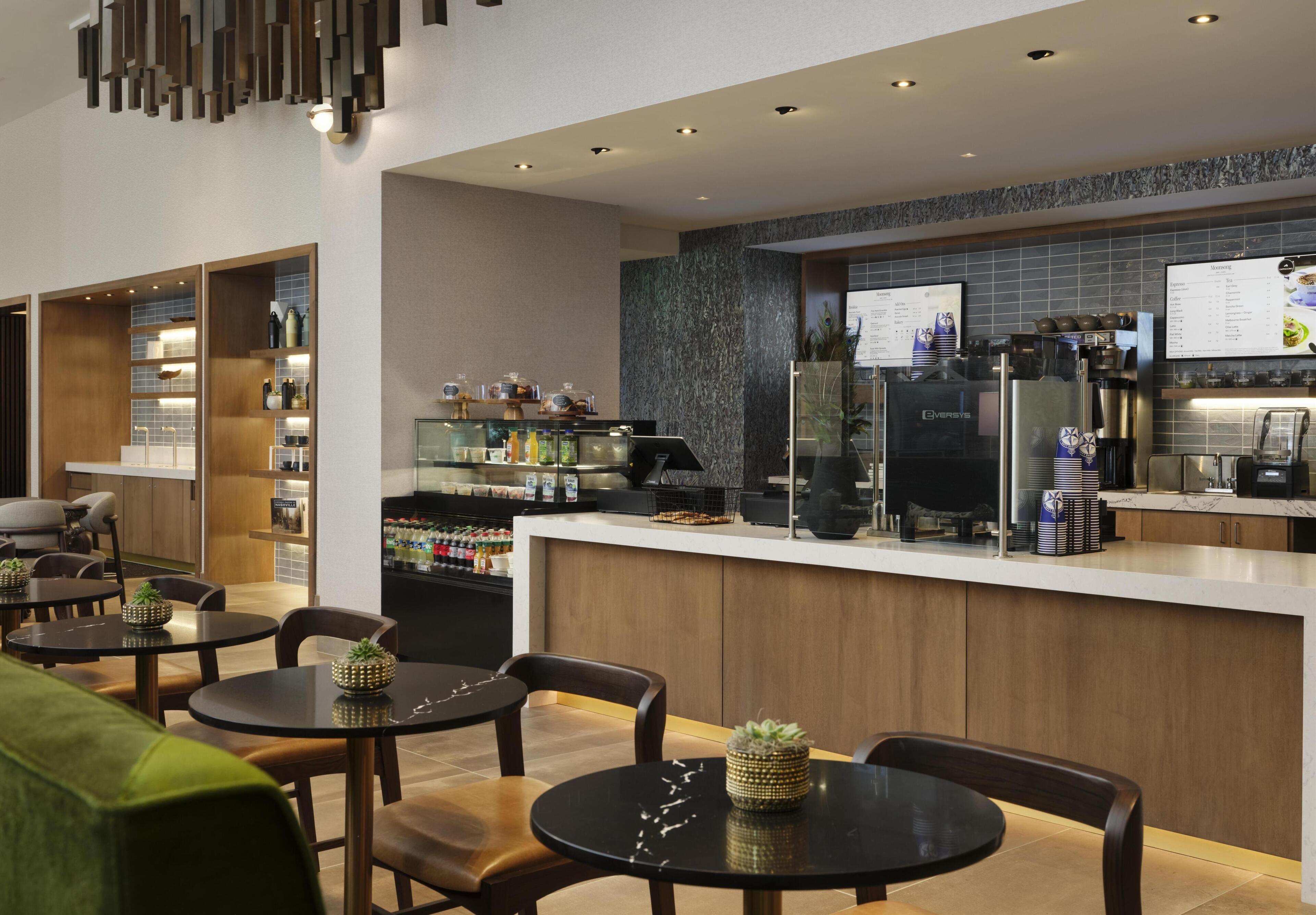 Una hall d'albergo moderna con area bar, posti a sedere e espositore del menu.