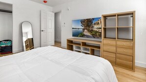 A bedroom with a large bed, a wardrobe, a mirror, and a TV displaying a scenic view. - NEW ! Stylish Loft in DT Pueblo – Sleeps up to 6 (Pueblo)