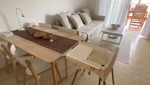 A dining area with a table and chairs, a sofa, and a ceiling fan. - Modern Apartment with Large Flower Terrace & Pool – Chayofa, Tenerife (Chayofa)