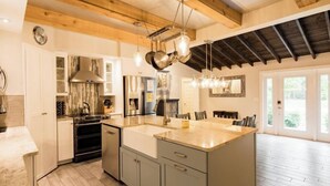 Una cucina moderna con una grande isola, elettrodomestici in acciaio inossidabile e soffitto in legno.