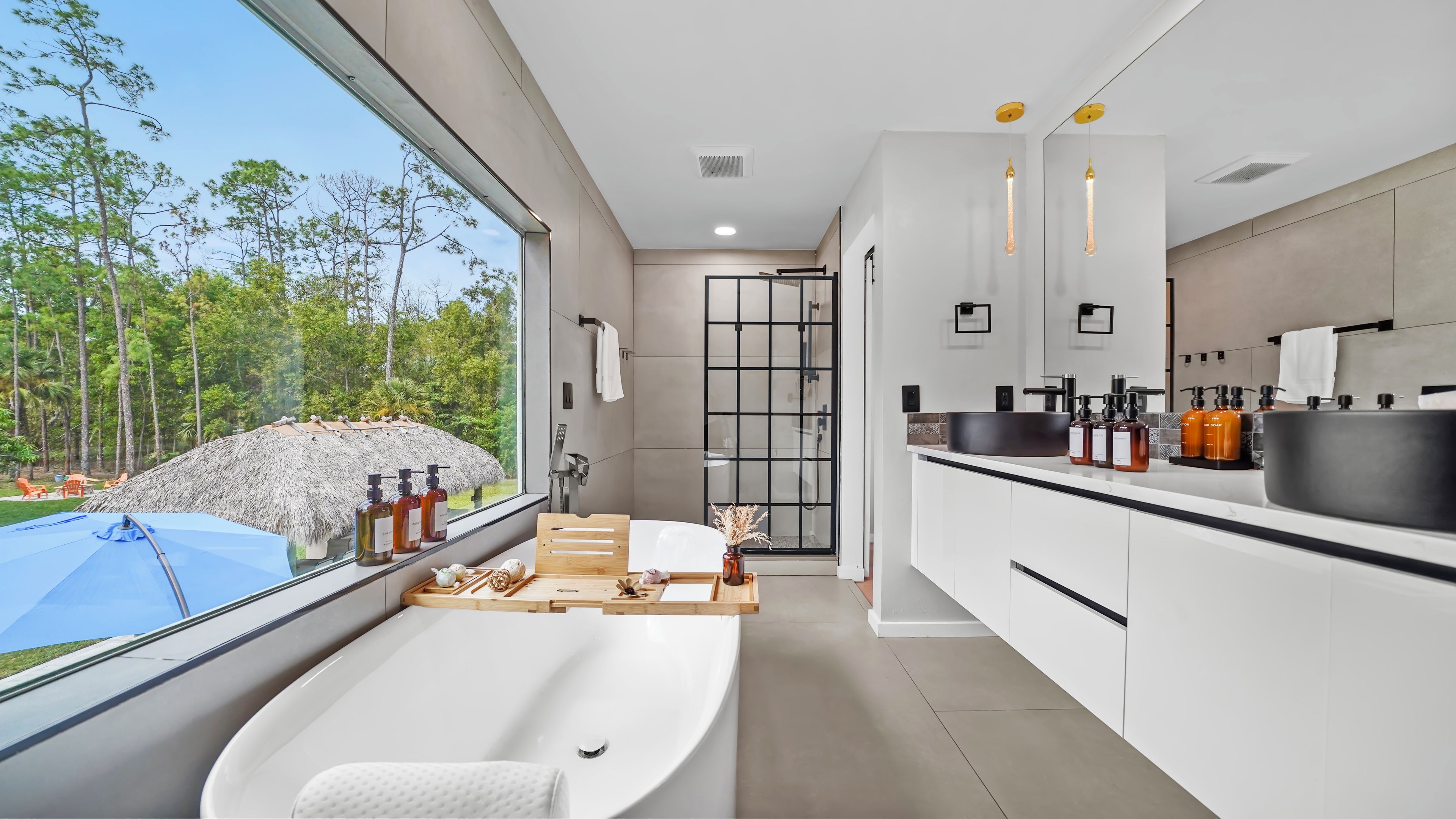 A modern bathroom with a large window, a bathtub, and a shower.