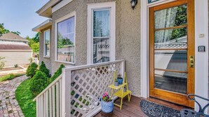 A house with a wooden deck, a white picket fence, and a front door with a glass panel. - Pensacola 1 BR Sleeps 2 Suite in East Hill (Pensacola)