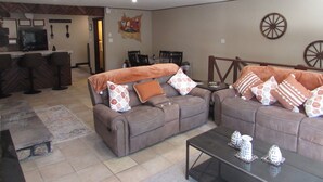 A living room with a sofa set, a coffee table, and a dining area with chairs and a table. - 2 Master Bedrooms-Full Bathrooms /Sleeps 7 /Fully Remodeled /Excellent Condition (Ruidoso)