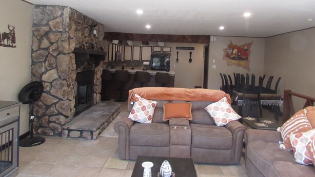 A cozy living room with a stone fireplace, a sofa set, and a dining area with chairs. - 2 Master Bedrooms-Full Bathrooms /Sleeps 7 /Fully Remodeled /Excellent Condition (Ruidoso)