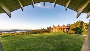 A large, open grassy area with a stone building in the background.