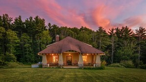 A house with a porch, a chimney, and a lawn.