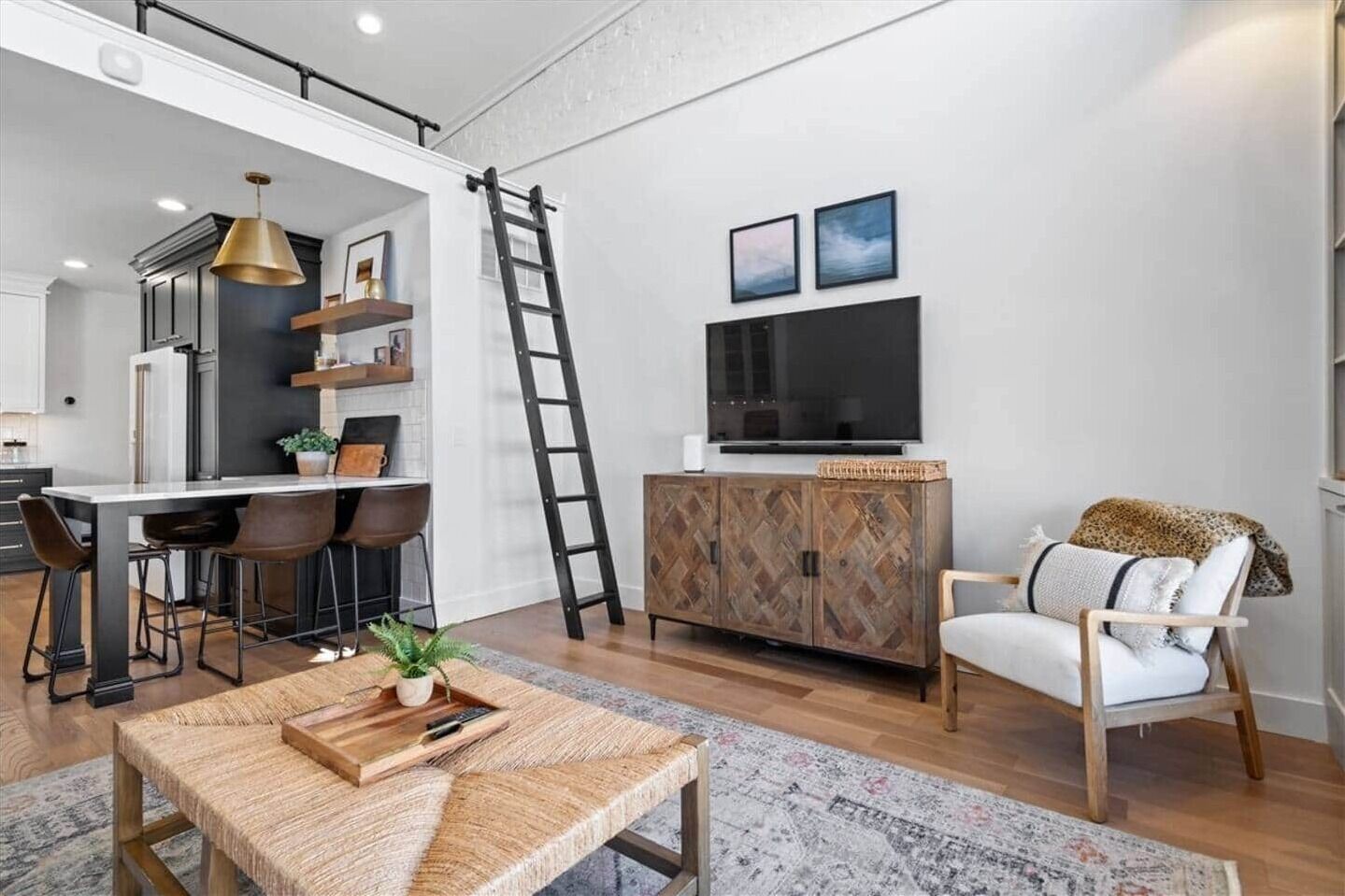 Una sala de estar moderna con comedor, un televisor montado en la pared y un mueble de madera.
