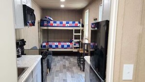Una cocina compacta con microondas, refrigerador y un pequeño comedor.