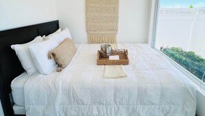 A neatly made bed with white bedding, a macrame wall hanging, and a breakfast tray on the bed. - Veranera 1 | Relaxing Private Heated Pool at Aguadilla (Aguadilla)