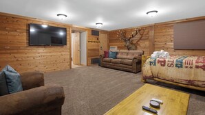 A log cabin interior with a TV, sofa, and coffee table.