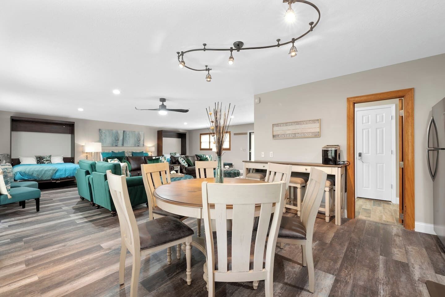 A modern living room with a dining area, a kitchen, and a bedroom.
