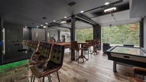 A pool table, bar area, and seating with a view of trees. - Private I Pool Table I Bar I Studio I House I Roku (Westerville)