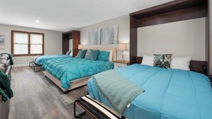 A bedroom with two beds, a window, and a painting on the wall.