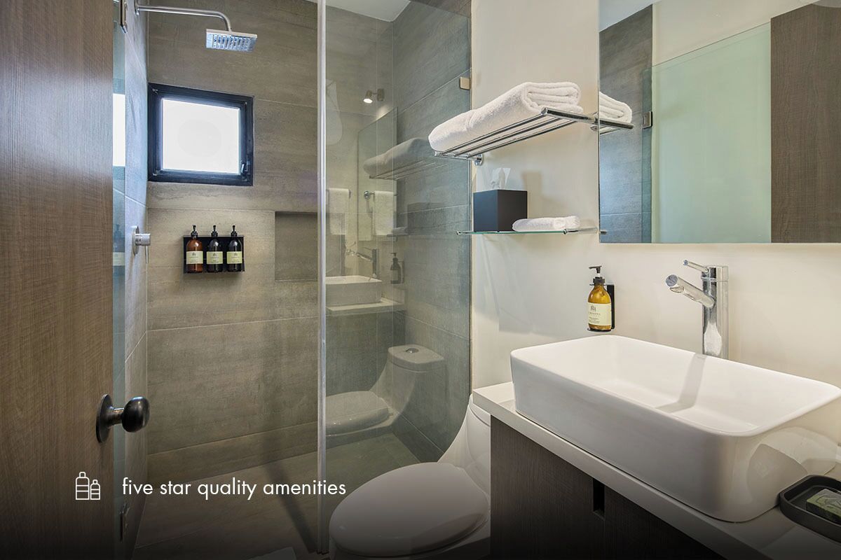 A modern bathroom with a glass-enclosed shower, a white sink, and a large mirror.
