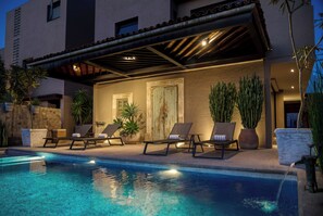 Un espace aménagé au bord de la piscine, avec des chaises longues et une pergola.