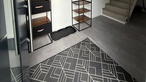 A modern interior with a staircase, built-in shelving, and a patterned rug. - StayEasy Accommodation (Gummersbach)