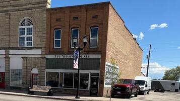 A two-story building with a brick facade, a storefront labeled "THE NEWS-MINER," and a sign reading "BEWARE OF THE BEARS."