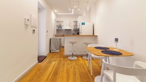 Eine moderne Küche mit weißen Schränken, einer Holzausziehtafel und einem eingebauten Backofen.