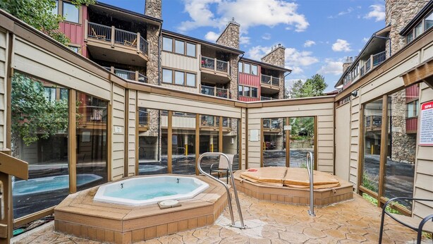 Ein Wellnessbereich mit zwei Whirlpools und einem Boden aus Steinplatten.