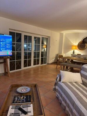 A living room with a TV, a dining table, and a sofa.