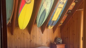 A bedroom with a bed, wooden walls, and surfboards mounted on the ceiling. - Surfrise manyana the surfers temple.sunrise ocean views native wildlife, (Manyana)