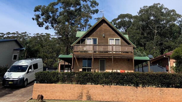 A two-story house with a balcony, surrounded by trees and a brick wall. - Surfrise manyana the surfers temple.sunrise ocean views native wildlife, (Manyana)