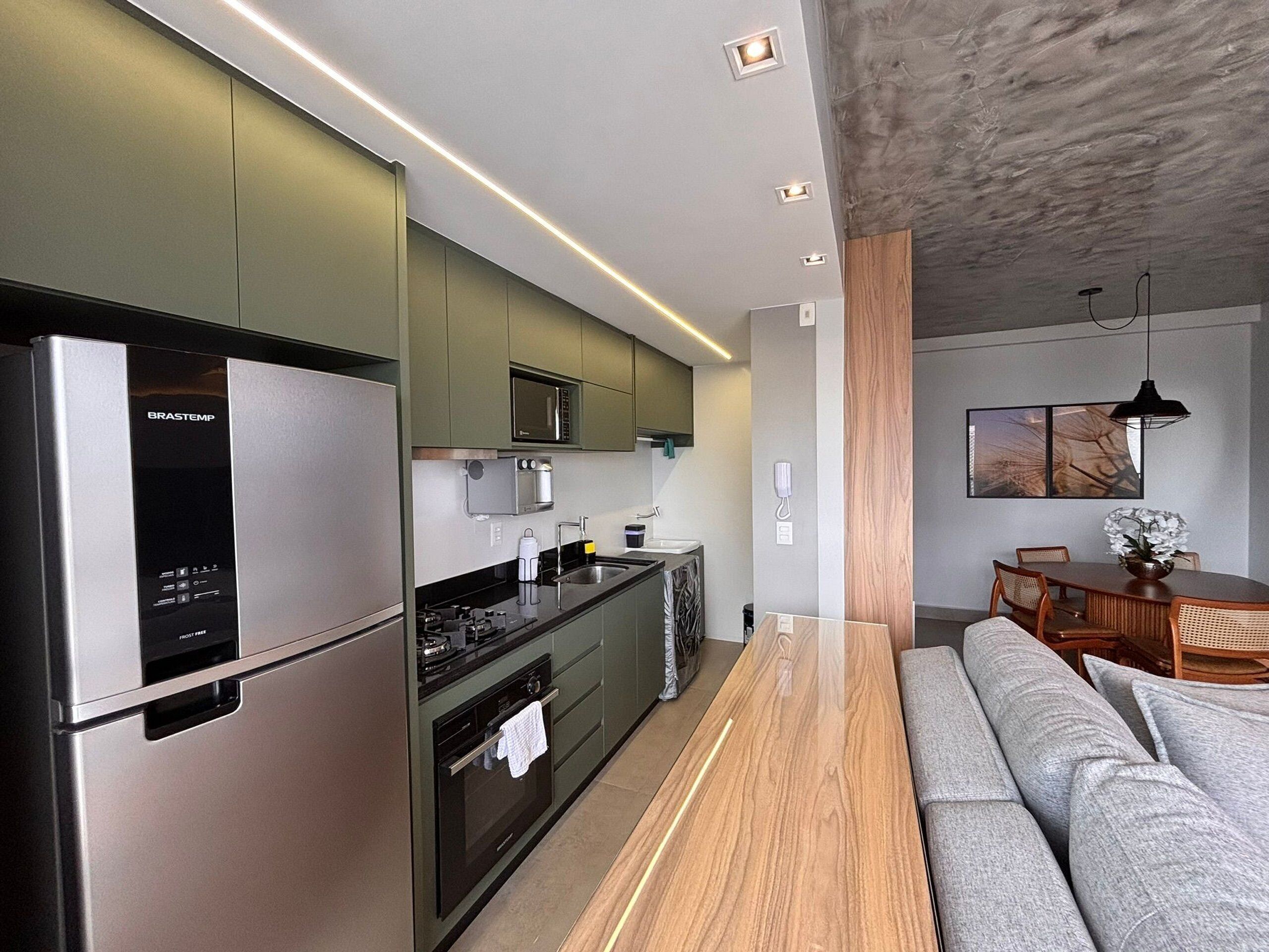 A modern kitchen with a refrigerator, microwave, and stove.