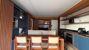 Un espacio habitable compacto con comedor, kitchenette y sofá.