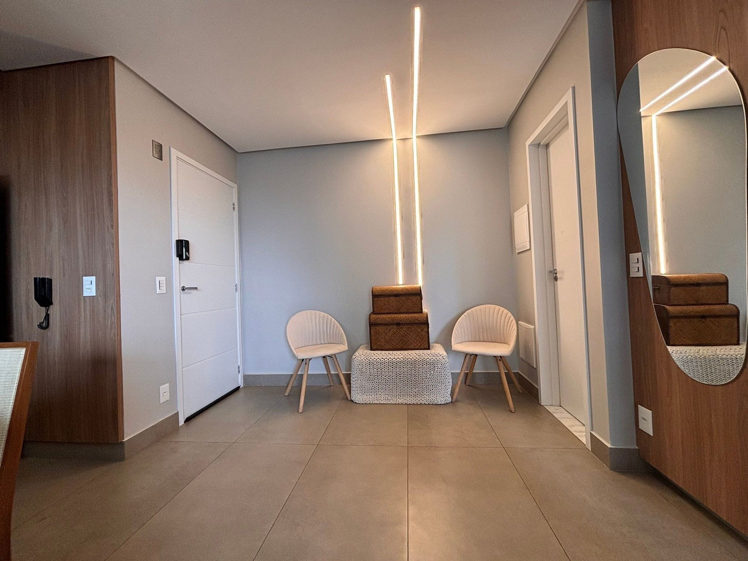 A hallway with a wooden door, a white bench, and a mirror on the wall.