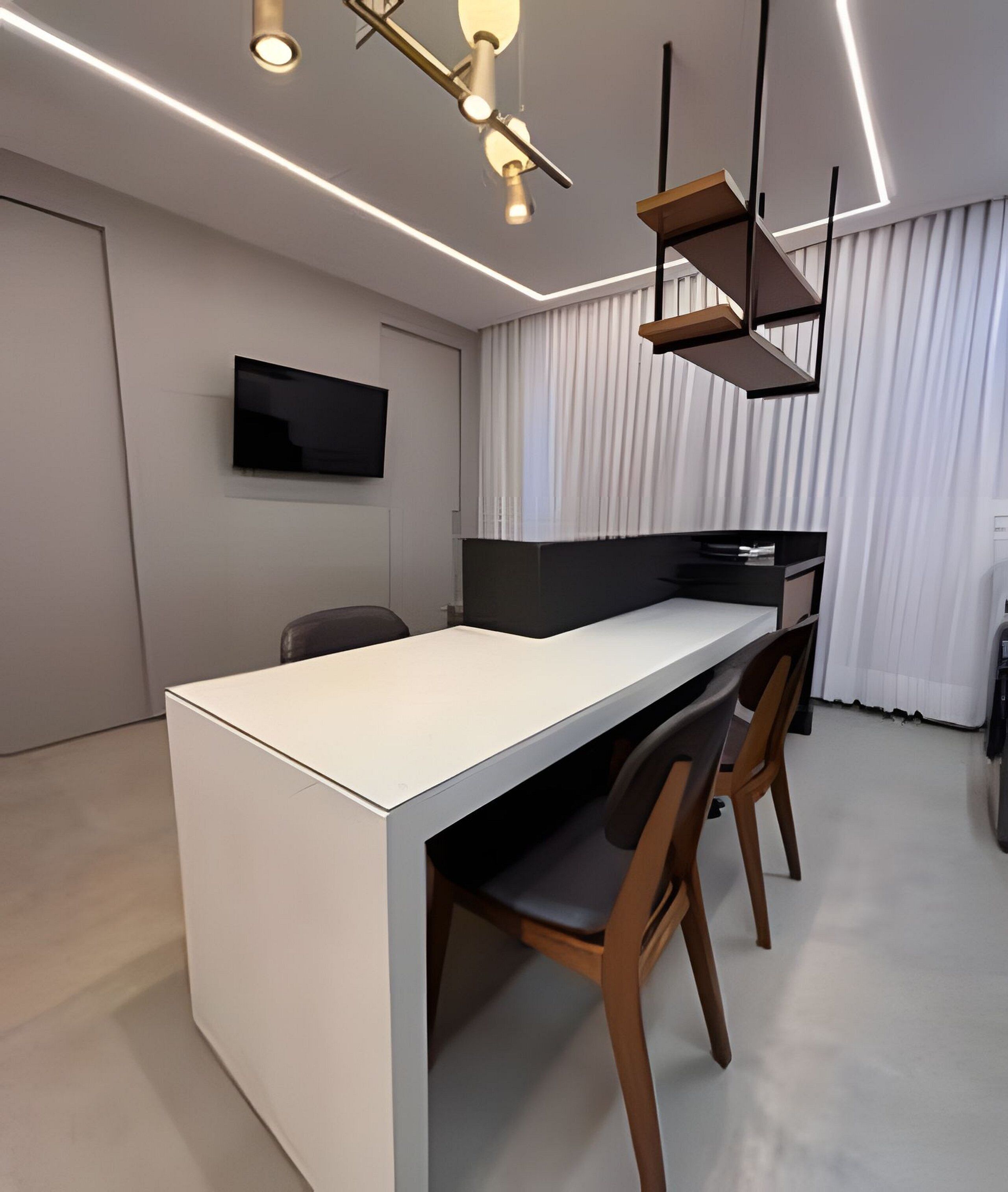 A modern kitchen with a built-in island, a flat-screen TV, and pendant lighting.