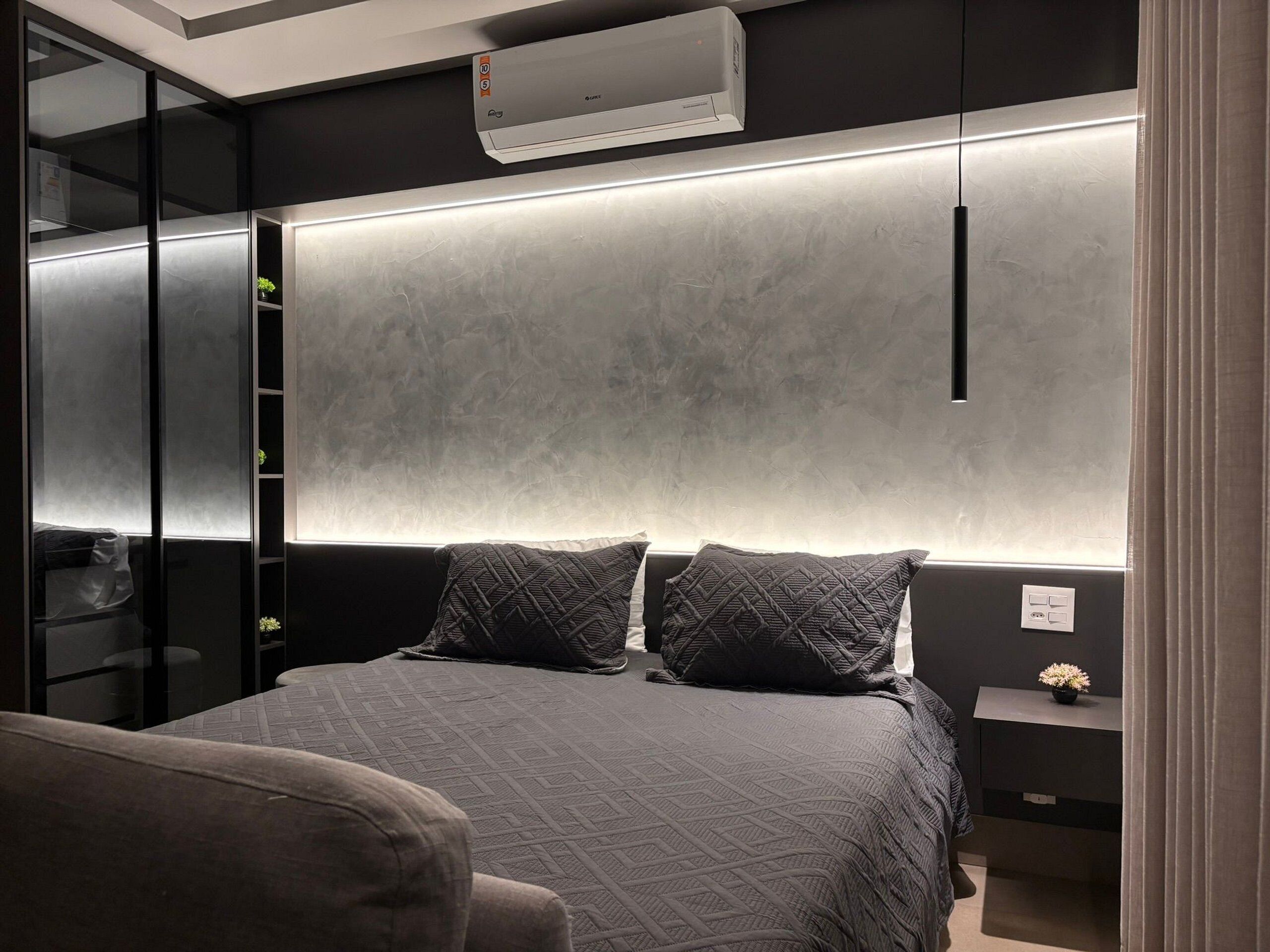 Een moderne slaapkamer met een bed, nachtkastjes en een inbouwkast.