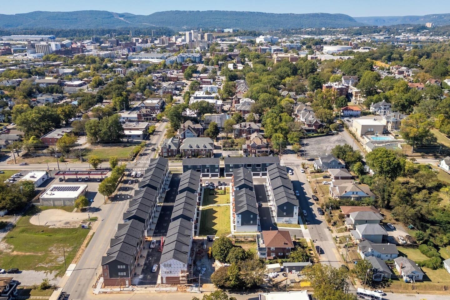 An aerial view of a residential area with a large building complex and surrounding houses.