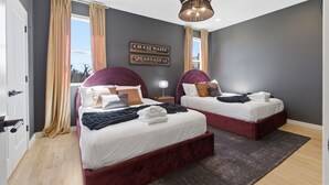 Ein Hotelzimmer mit zwei Betten, einem Kronleuchter und Blick nach außen.