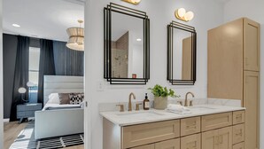 Un bagno moderno con doppio lavabo, un grande specchio e un armadietto in legno.