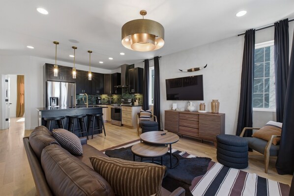 A modern living room with a sofa, a coffee table, and a TV.
