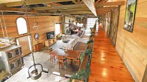 Un hall d’hôtel spacieux, doté de parquets en bois, d’un espace salon central et d’un long comptoir.